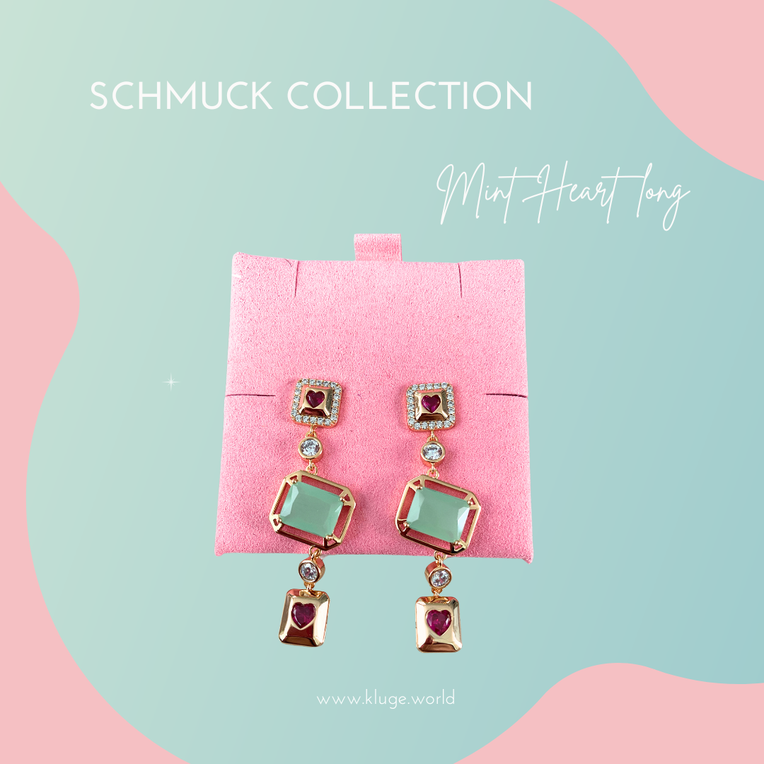 Mint Heart Short Ohrringe aus der Schmuckkollektion von Kluge Beauty. Elegante goldene Ohrringe mit roten Herz-Details, funkelnden Zirkonia und mintfarbenen Steinen. Präsentiert auf einer mintgrünen Schmuckverpackung vor einem pastellfarbenen Hintergrund mit rosa und blauen Akzenten. Ideal für einen stilvollen und luxuriösen Look.