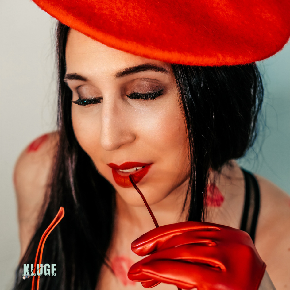 Nahaufnahme einer Frau mit kräftigem roten Lippenstift, eleganten roten Handschuhen und einer stilvollen roten Mütze, die einen modernen Look verkörpert.