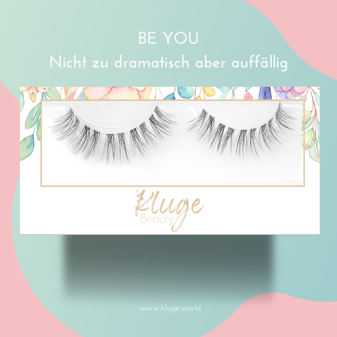 Produktfoto der "Be You" Wimpernbox, betont durch einen natürlichen Look, stilvoll dargestellt auf einem farbenfrohen, verspielten Hintergrund.